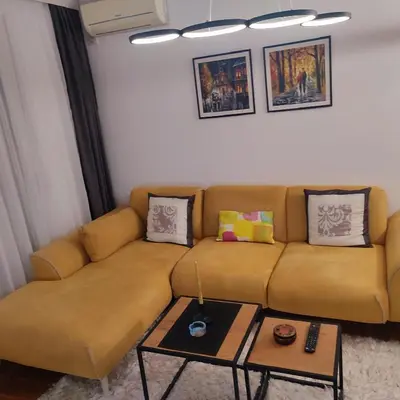 a brown couch in a living room with a table at Banjski apartman in Vrnjačka Banja
