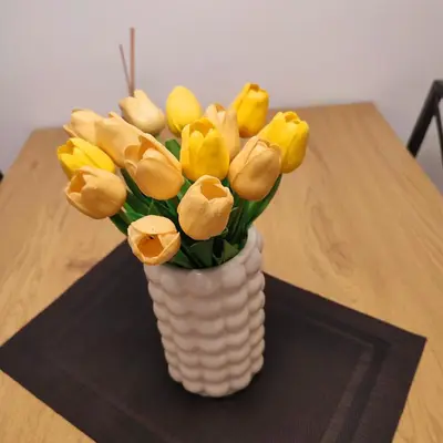 a vase filled with yellow tulips sitting on a table at Banjski apartman in Vrnjačka Banja