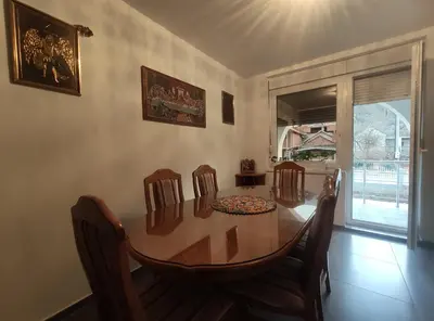 a dining room with a wooden table and chairs at VILA RUŽA - Grand apartman 1 in Soko Banja
