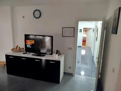 a living room with a flat screen tv on a desk at VILA RUŽA - Grand apartman 1 in Soko Banja