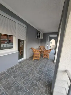 a patio with a table and chairs in a house at VILA RUŽA - Grand apartman 1 in Soko Banja