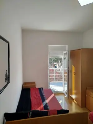 a bedroom with a bed and a sliding glass door at VILA RUŽA - Grand apartman 1 in Soko Banja
