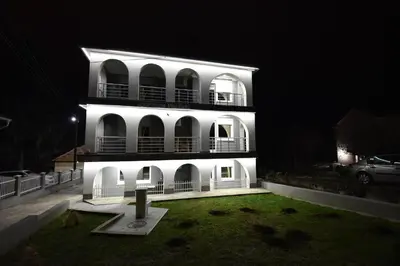 a white building with a yard in front of it at night at VILA RUŽA - Grand apartman 1 in Soko Banja