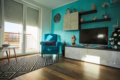 a living room with a television and a blue chair at Urbanic Apartment Aquapark & Free Parking in Vrnjačka Banja