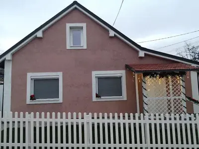 a house with a white fence in front of it at Apartman SIMONA in Bor