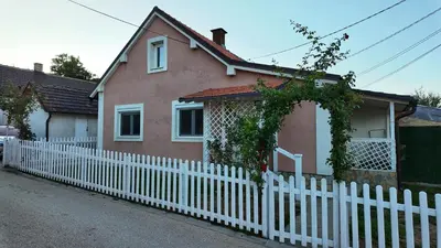 a white picket fence in front of a house at Apartman SIMONA in Bor