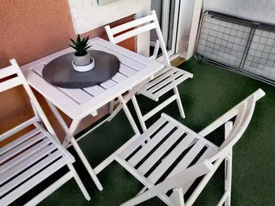 a white table and chairs with a potted plant on it at Apartman SIMONA in Bor