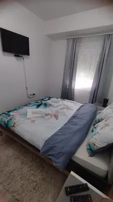 a bed sitting in a room with a television at Apartman Kamelia in Jagodina