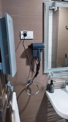 a bathroom with a phone on the wall next to a mirror at Apartman Kamelia in Jagodina