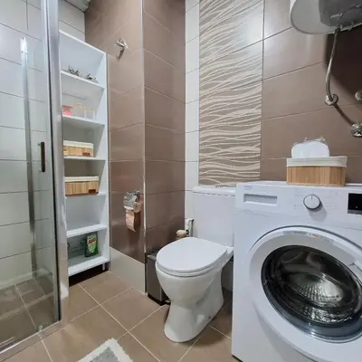 a bathroom with a toilet and a washing machine at Apartman Kamelia in Jagodina