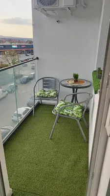 a balcony with two chairs and a table and a table at Apartman Kamelia in Jagodina