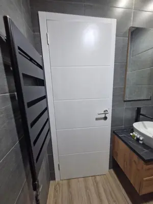 a white door in a bathroom with a sink at RELAX RESIDENS-kopaonik in Kopaonik