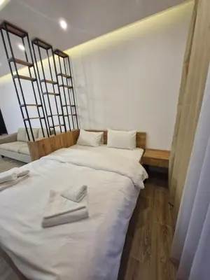 a bedroom with a large white bed with towels on it at RELAX RESIDENS-kopaonik in Kopaonik