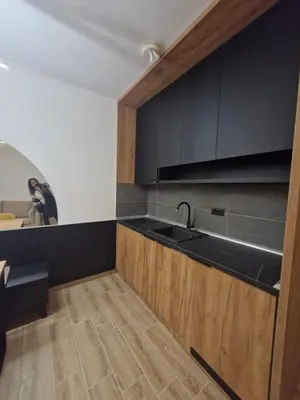 a kitchen with black cabinets and a sink at RELAX RESIDENS-kopaonik in Kopaonik