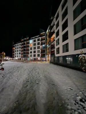 an empty street in front of buildings at night at RELAX RESIDENS-kopaonik in Kopaonik