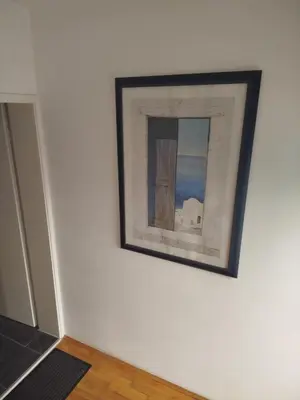 a painting on a white wall with a mirror at VILA RUŽA - Grand apartman 2 in Soko Banja