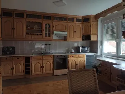a kitchen with wooden cabinets and a sink at VILA RUŽA - Grand apartman 2 in Soko Banja