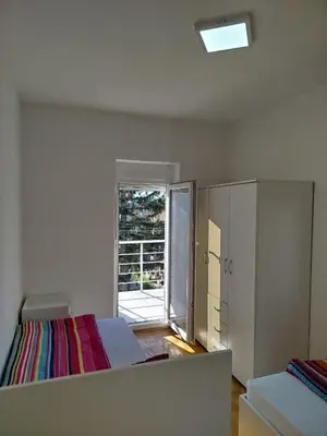 a bedroom with a bed and a door to a balcony at VILA RUŽA - Grand apartman 2 in Soko Banja