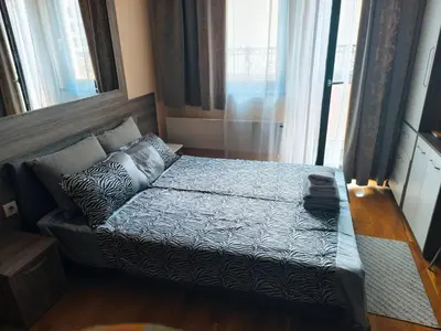 a bed in a room with a large window at Central Park in Niš