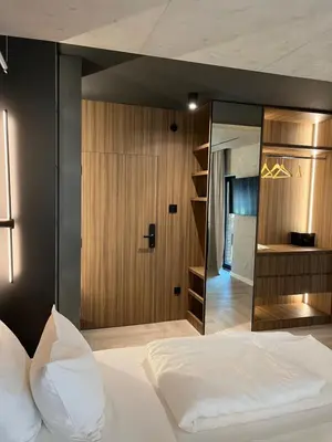 a bedroom with a large white bed and a mirror at Open Space in Niš