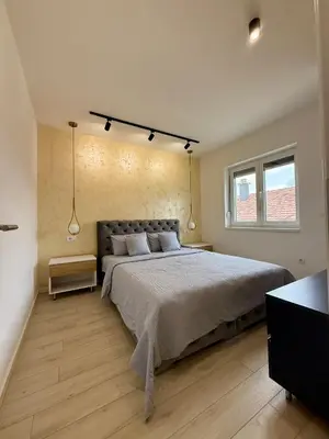 a bedroom with a large bed and a window at Cvetkovic apartman in Soko Banja