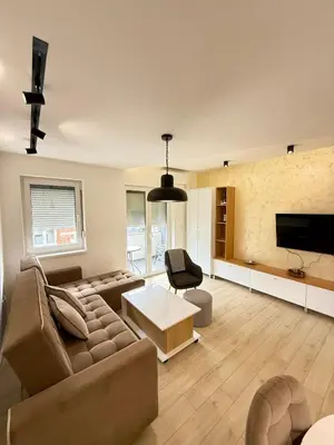 a large living room with a couch and a tv at Cvetkovic apartman in Soko Banja