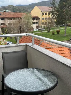 a table and a chair sitting on a balcony at Cvetkovic apartman in Soko Banja