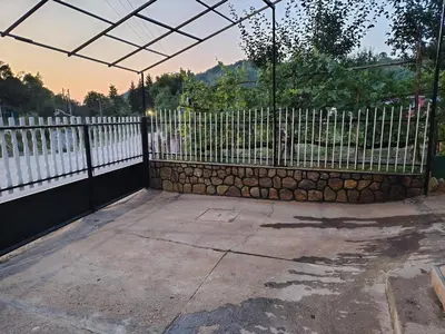 a black fence with a stone wall next to a gate at Smestaj Bojanine Vode in Niš