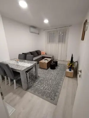 a living room with a table and a couch at Apartman Una in Soko Banja
