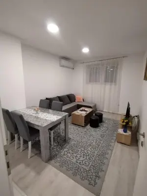 a living room with a table and a couch at Apartman Una in Soko Banja