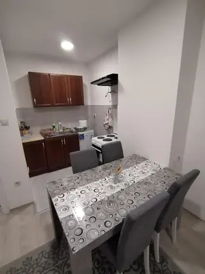 a kitchen with a table and chairs and a kitchen with a kitchen at Apartman Una in Soko Banja
