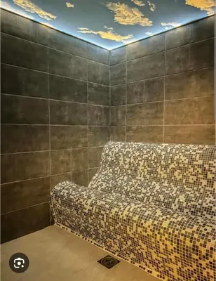 a couch in a room with a wall with a ceiling at President kop APP Katarina II free wellnes&spa in Kopaonik