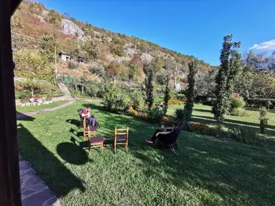 a group of people sitting on chairs in a yard at Vila Petrov in Lukavica