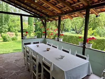a white table and chairs on a patio at Vila Petrov in Lukavica