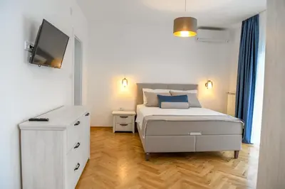 a bedroom with a bed with a television and a dresser at Vila sa bazenom Vrnjačka Idila in Vrnjačka Banja