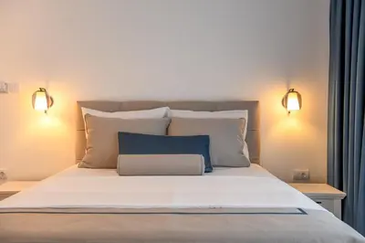 a bed with two lights and a blue pillow on it at Vila sa bazenom Vrnjačka Idila in Vrnjačka Banja