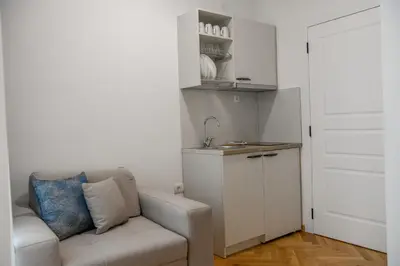 a living room with a couch and a kitchen at Vila sa bazenom Vrnjačka Idila in Vrnjačka Banja