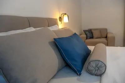 a couch with a blue pillow in a living room at Vila sa bazenom Vrnjačka Idila in Vrnjačka Banja