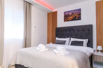 a bedroom with a large bed with towels on it at BOŽUR apartmani, kod hotela Sunce in Soko Banja