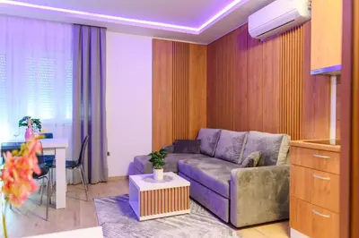 a living room with a couch and a table at BOŽUR apartmani, kod hotela Sunce in Soko Banja