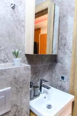 a bathroom with a sink and a mirror at BOŽUR apartmani, kod hotela Sunce in Soko Banja