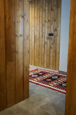 a room with a wooden wall and a door with a rug at NOOK Kopaonik Luxury Apart & House in Kopaonik