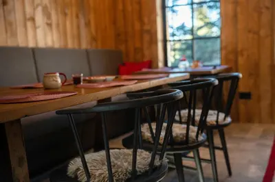 a row of bar stools at a table in a restaurant at NOOK Kopaonik Luxury Apart & House in Kopaonik