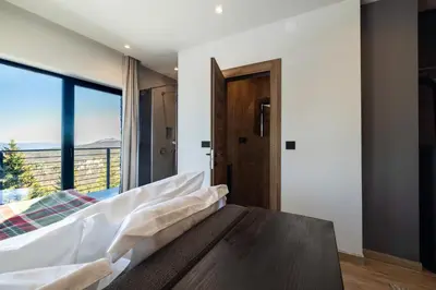 a bedroom with a bed and a large window at NOOK Kopaonik Luxury Apart & House in Kopaonik