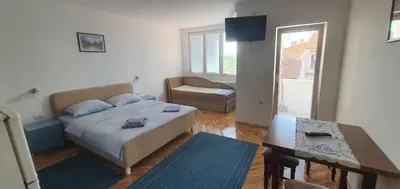 a small room with a bed and a table and a couch at Apartmani Vučić in Soko Banja
