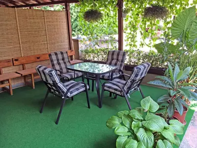 a patio with a table and chairs and a bench at Apartmani Vučić in Soko Banja