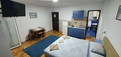 a living room with a table and a kitchen at Apartmani Vučić in Soko Banja