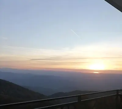 a view of the sun setting over the mountains at Magia Vido Apartment-President Kop A109 in Kopaonik
