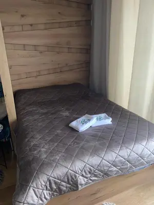 a bed in a room with a wooden wall at Magia Vido Apartment-President Kop A109 in Kopaonik