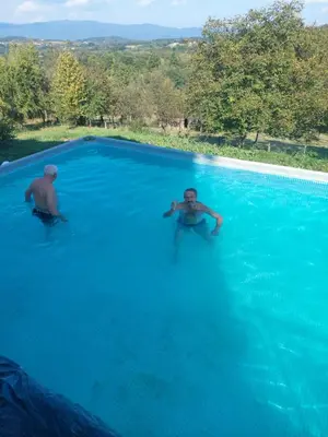 two men are swimming in a swimming pool at Jagoda In in Otroci